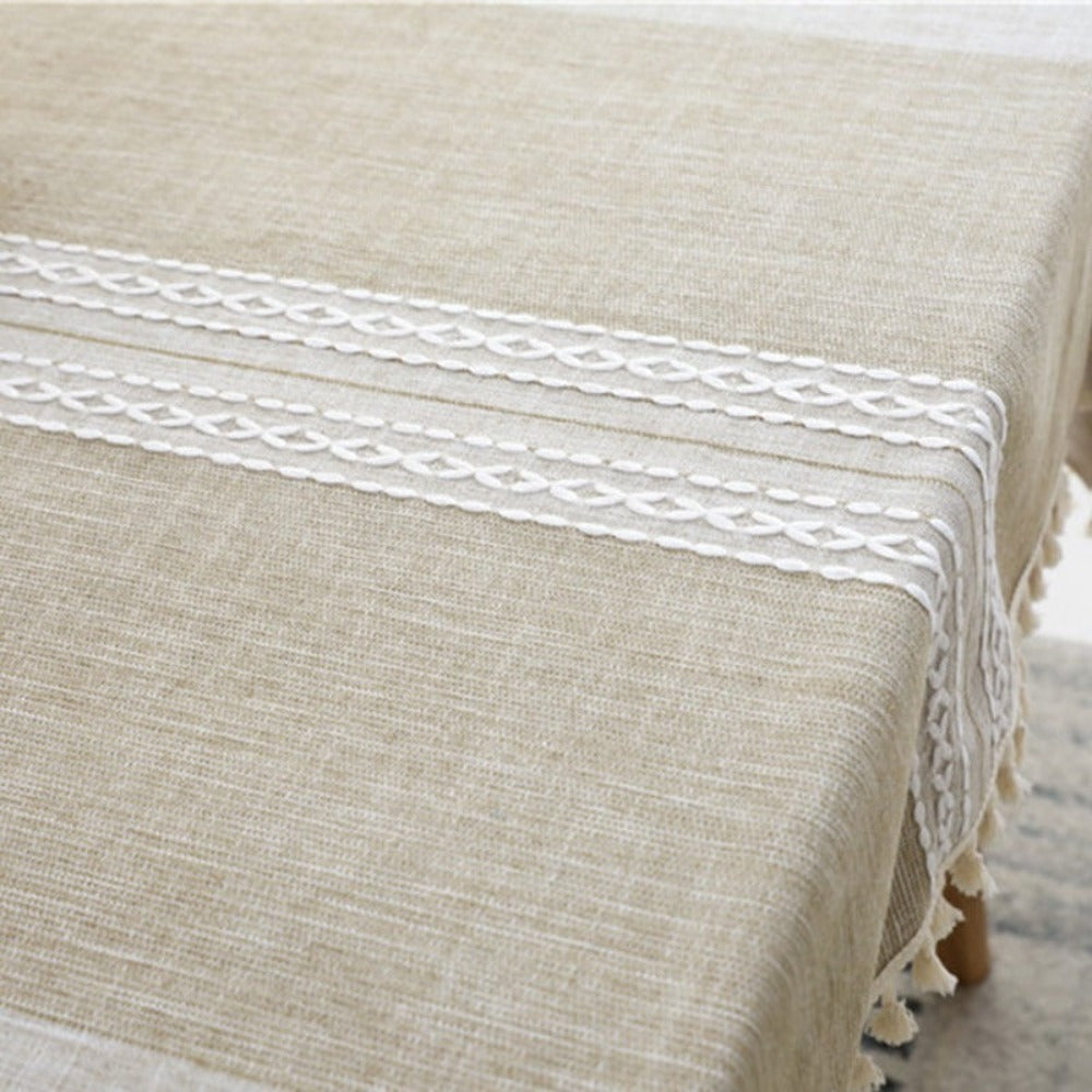 Mantel Rectangular café claro en laterales con franja central de tono más oscuro con bordados blancos centrales y borde de borlas de color beige, lo puedes usar para decorar tus mesas de comedor, comedor de diario y mesas en general de tus espacios y hogar. Mantel rectangular Color: Café Claro Con Borlas color crema en el borde Material: Lino Mantel tiene medidas de 140 cm x 220 cm y 140 cm x 200 cm.